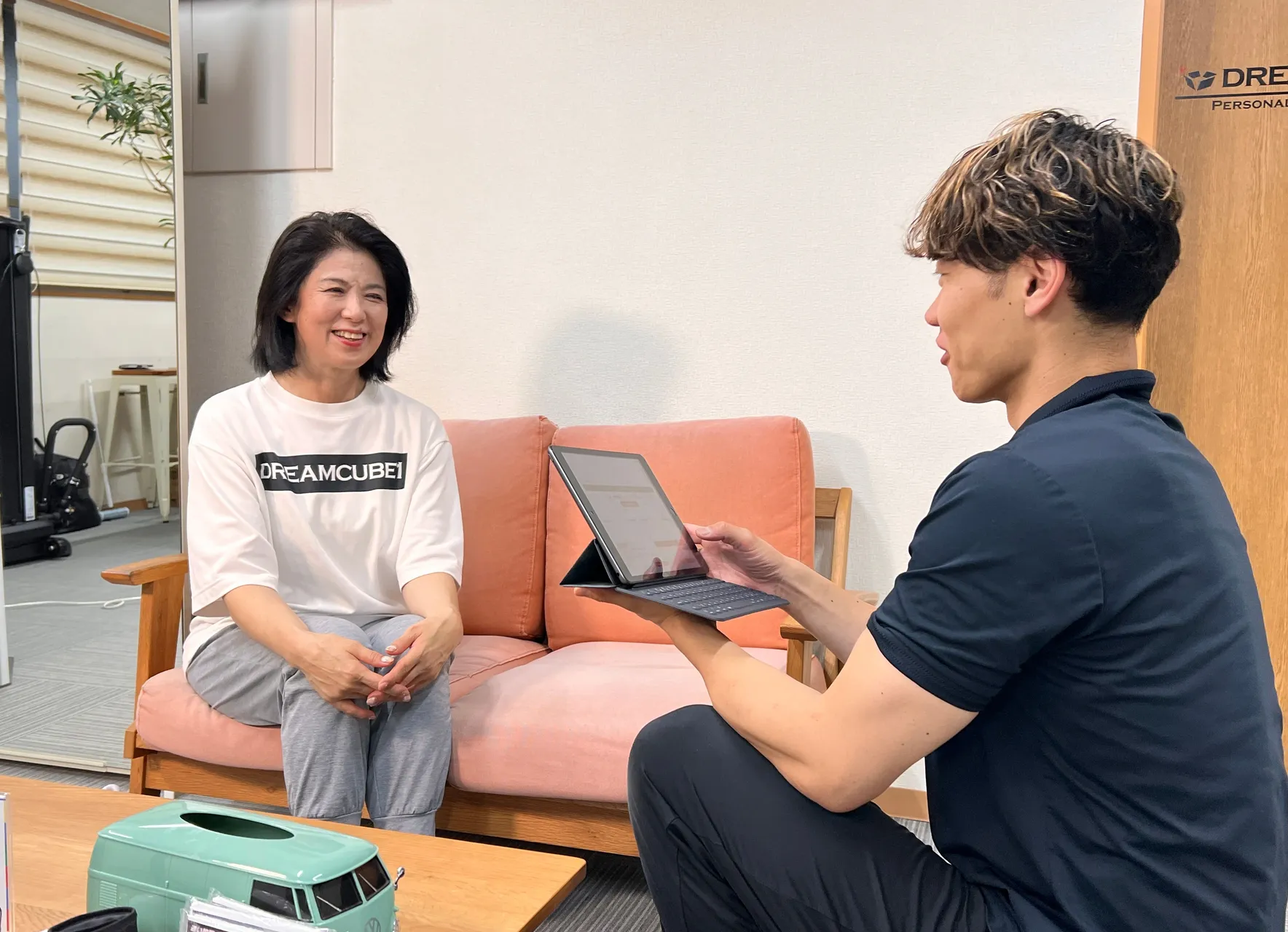 タブレットを使ってカウンセリングをするトレーナー