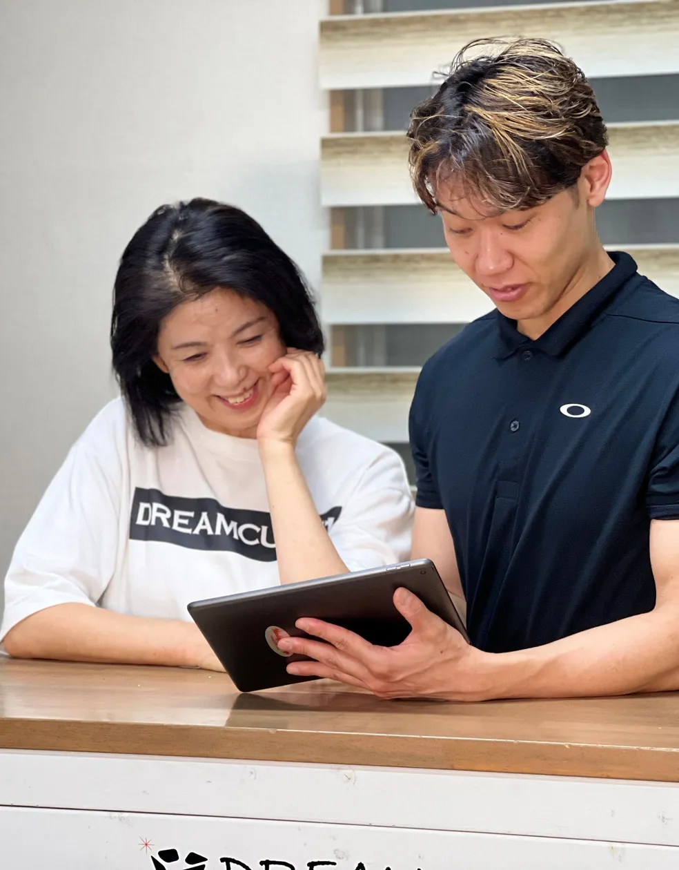 タブレットを見ながらお客様と話すトレーナー