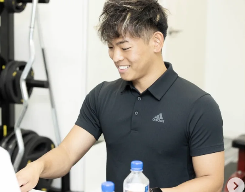 トレーナーが笑顔で指導する様子