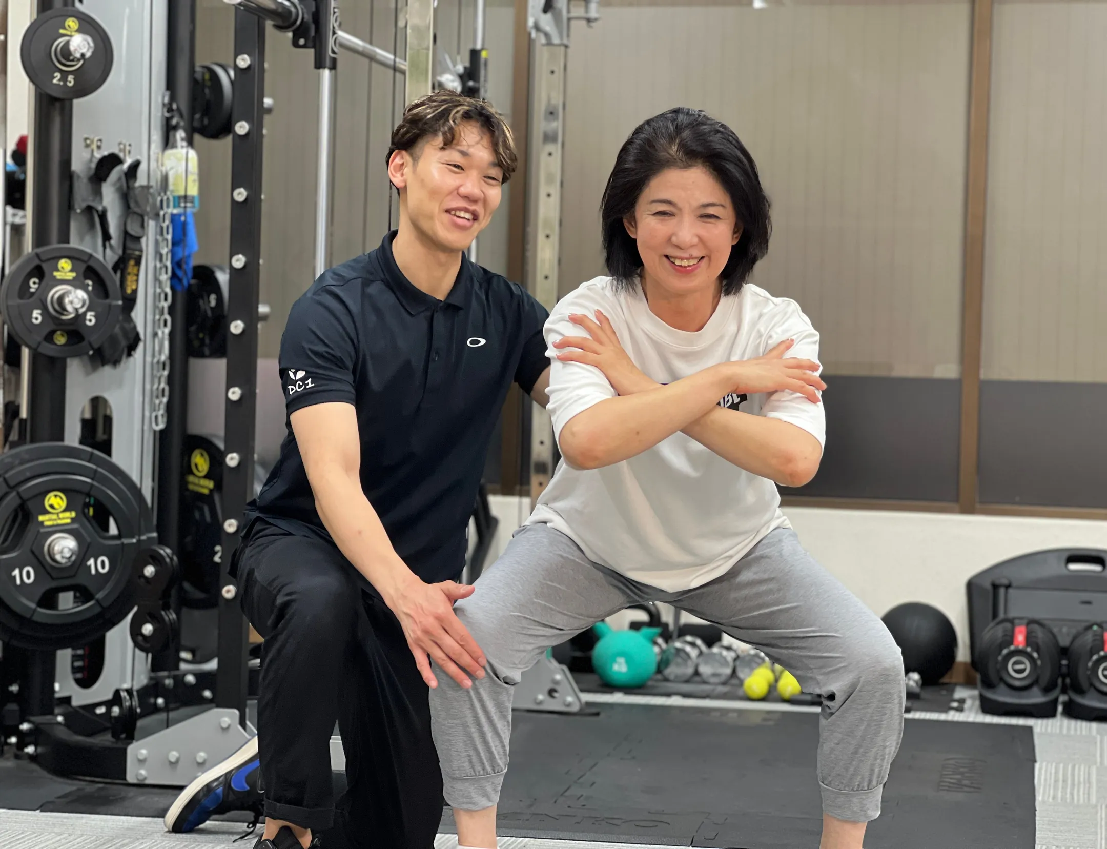 トレーナーと並んで笑顔の女性会員