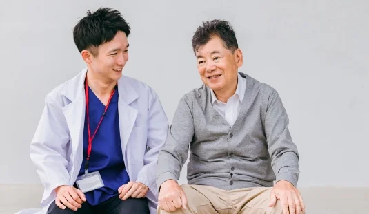 医師とシニア男性が笑顔で話す様子